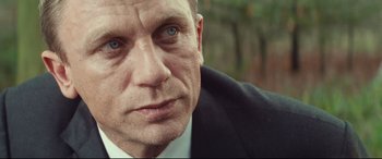 Movie still from “Layer Cake” (2004), directed by Matthew Vaughn – A person wearing a suit and tie; Close Up shot, Over the shoulder angle