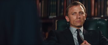 Movie still from “Layer Cake” (2004), directed by Matthew Vaughn – A person wearing a suit and tie; Close Up shot, Over the shoulder angle