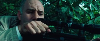Movie still from “Layer Cake” (2004), directed by Matthew Vaughn – A man is looking through a rifle scope; Close Up shot, Low angle
