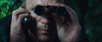 Movie still from “Layer Cake” (2004), directed by Matthew Vaughn – A person looking through binoculars; Close Up shot, Low angle