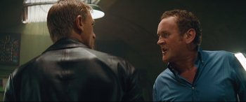 Movie still from “Layer Cake” (2004), directed by Matthew Vaughn – Two men talking to each other in a dark room; Close Up shot, Over the shoulder angle