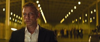 Movie still from “Layer Cake” (2004), directed by Matthew Vaughn – A person wearing a suit and tie; Close Up shot, Over the shoulder angle