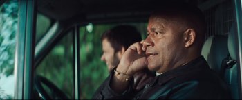 Movie still from “Layer Cake” (2004), directed by Matthew Vaughn – A man in a car talking on a cell phone; Close Up shot, Low angle