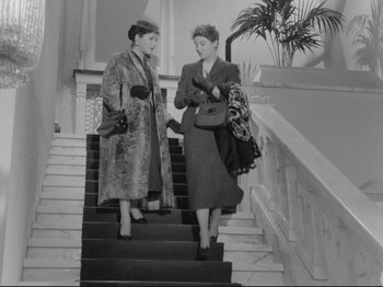 Movie still from “The Girlfriends” (1955), directed by Michelangelo Antonioni – A couple of women walking up some stairs; Wide shot, Low angle