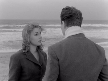 Movie still from “The Girlfriends” (1955), directed by Michelangelo Antonioni – A man and a woman standing next to each other on the beach; Medium shot, Over the shoulder angle