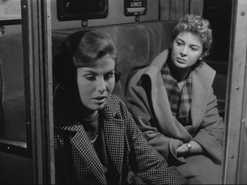 Movie still from “The Girlfriends” (1955), directed by Michelangelo Antonioni – A couple of women sitting next to each other on a train; Medium shot, High angle