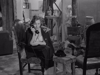 Movie still from “The Girlfriends” (1955), directed by Michelangelo Antonioni – A woman sitting in a chair talking on the phone; Medium shot, High angle