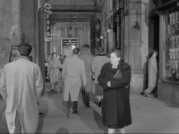 Movie still from “The Girlfriends” (1955), directed by Michelangelo Antonioni – A black and white photo of people walking down a street; Wide shot, High angle