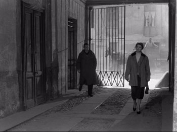Movie still from “The Girlfriends” (1955), directed by Michelangelo Antonioni – Two women are walking down the sidewalk in the city; Wide shot, Over the shoulder angle
