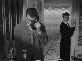 Movie still from “The Girlfriends” (1955), directed by Michelangelo Antonioni – A man and a woman are standing in front of a phone; Medium shot, Low angle