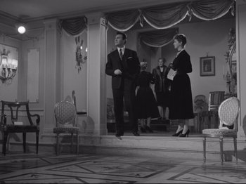 Movie still from “The Girlfriends” (1955), directed by Michelangelo Antonioni – A black and white photo of a man and a woman in formal wear; Wide shot, Low angle