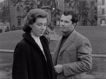 Movie still from “The Girlfriends” (1955), directed by Michelangelo Antonioni – An older man and a younger woman standing next to each other in front of a building; Medium shot, Low angle