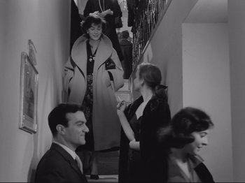 Movie still from “The Girlfriends” (1955), directed by Michelangelo Antonioni – A group of people standing on stairs in a room; Medium shot, Over the shoulder angle