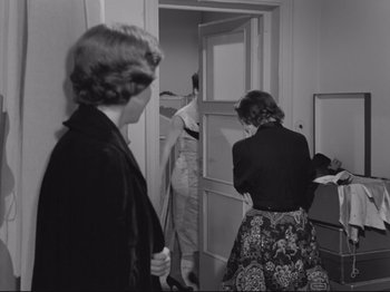 Movie still from “The Girlfriends” (1955), directed by Michelangelo Antonioni – Two women are standing in a doorway and one of the women is holding papers; Medium shot, Over the shoulder angle