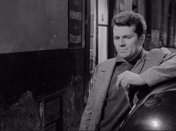 Movie still from “The Girlfriends” (1955), directed by Michelangelo Antonioni – A black and white photo of a man leaning against a wall; Medium shot, High angle