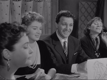 Movie still from “The Girlfriends” (1955), directed by Michelangelo Antonioni – A group of people sitting around a table; Medium shot, Over the shoulder angle