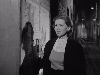Movie still from “The Girlfriends” (1955), directed by Michelangelo Antonioni – A black and white photo of a woman standing in front of a wall; Medium shot, Low angle