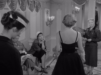 Movie still from “The Girlfriends” (1955), directed by Michelangelo Antonioni – A group of people sitting around in a room; Medium shot, Over the shoulder angle