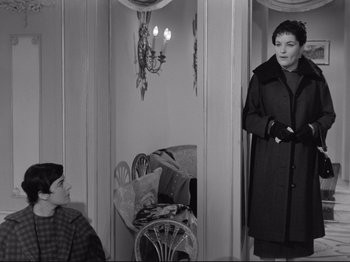 Movie still from “The Girlfriends” (1955), directed by Michelangelo Antonioni – A woman standing in front of a man in front of a mirror; Medium shot, Over the shoulder angle