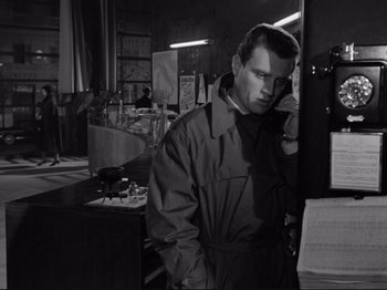 Movie still from “The Girlfriends” (1955), directed by Michelangelo Antonioni – A black and white photo of a man standing in front of papers; Medium shot, Low angle