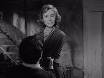 Movie still from “The Girlfriends” (1955), directed by Michelangelo Antonioni – A woman standing next to a man in front of a wall; Medium shot, Over the shoulder angle