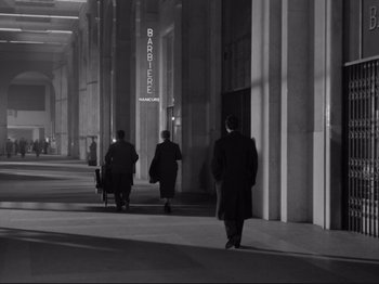 Movie still from “The Girlfriends” (1955), directed by Michelangelo Antonioni – Three people are walking down the sidewalk in the dark; Extreme Wide shot, Over the shoulder angle