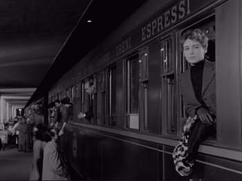 Movie still from “The Girlfriends” (1955), directed by Michelangelo Antonioni – A black and white photo of a woman sitting on a train; Wide shot, Low angle