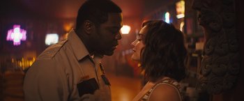 A man and a woman face to face in front of lights