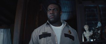 A man in a white t - shirt wearing a gray jacket