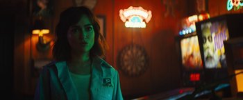 A woman standing in front of a neon sign
