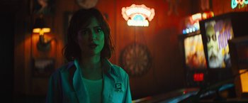 A woman standing in front of a dart board in a room
