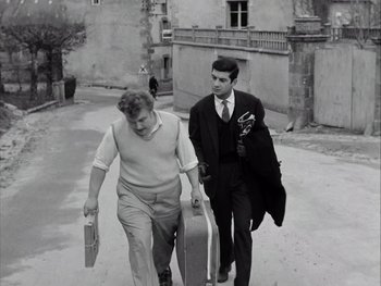 Movie still from “Le Beau Serge” (1958), directed by Claude Chabrol – Two men walking down the street carrying suitcases; Medium shot, Low angle