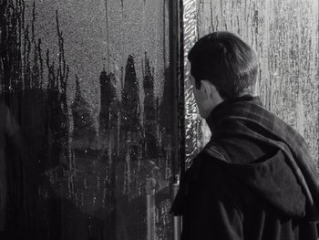 Movie still from “Le Beau Serge” (1958), directed by Claude Chabrol – A man standing in front of a window looking at the rain; Close Up shot, High angle