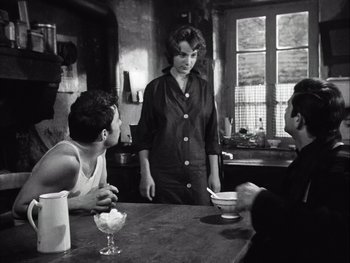 Movie still from “Le Beau Serge” (1958), directed by Claude Chabrol – A woman standing at a table in front of two men; Medium shot, Over the shoulder angle