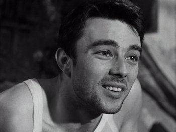 Movie still from “Le Beau Serge” (1958), directed by Claude Chabrol – Black and white photograph of a young man smiling; Close Up shot, Low angle