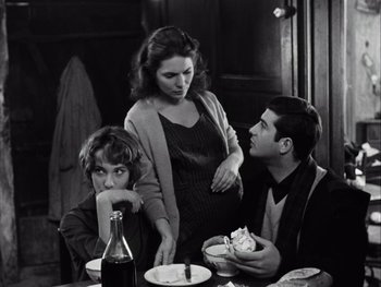 Movie still from “Le Beau Serge” (1958), directed by Claude Chabrol – A group of people sitting at a table with food; Medium shot, Over the shoulder angle