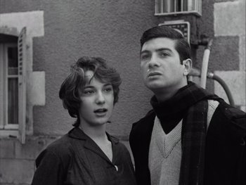 Movie still from “Le Beau Serge” (1958), directed by Claude Chabrol – A man and a woman standing next to each other in front of a building; Close Up shot, Low angle