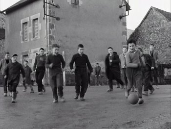 Movie still from “Le Beau Serge” (1958), directed by Claude Chabrol – A black and white photo of a group of young boys playing soccer; Wide shot, High angle
