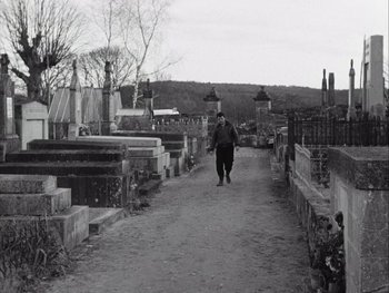 Movie still from “Le Beau Serge” (1958), directed by Claude Chabrol – A man walking down a dirt path in a cemetery; Wide shot, High angle