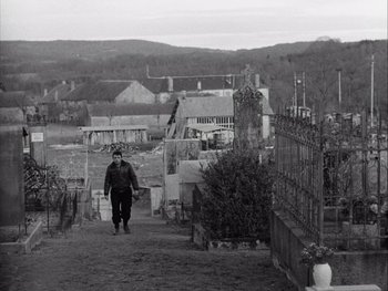 Movie still from “Le Beau Serge” (1958), directed by Claude Chabrol – A man walking down a dirt path in a cemetery; Extreme Wide shot, High angle