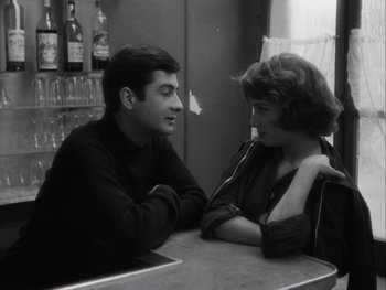 Movie still from “Le Beau Serge” (1958), directed by Claude Chabrol – A man and a woman sitting at a table; Medium shot, High angle