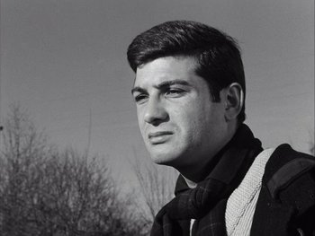 Movie still from “Le Beau Serge” (1958), directed by Claude Chabrol – Black and white photograph of a young man in a plaid shirt; Close Up shot, Low angle