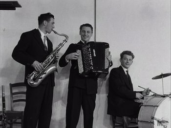 Movie still from “Le Beau Serge” (1958), directed by Claude Chabrol – A group of young men in suits playing instruments; Medium shot, Low angle