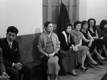 Movie still from “Le Beau Serge” (1958), directed by Claude Chabrol – A black and white photo of a group of people sitting on a bench; Medium shot, High angle