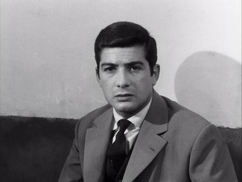 Movie still from “Le Beau Serge” (1958), directed by Claude Chabrol – Black and white photograph of a man wearing a suit and tie; Close Up shot, Low angle