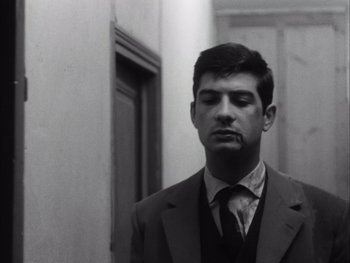 Movie still from “Le Beau Serge” (1958), directed by Claude Chabrol – A black and white photo of a man in a suit and tie; Close Up shot, Low angle