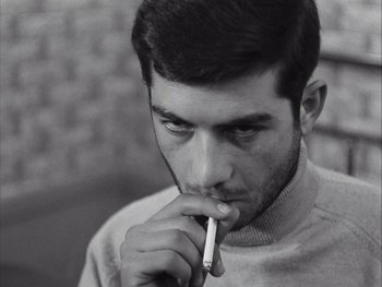Movie still from “Le Beau Serge” (1958), directed by Claude Chabrol – A young man holding a cigarette in his mouth; Close Up shot, Low angle