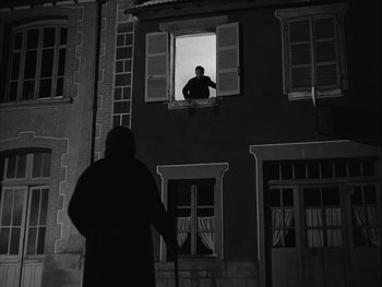 Movie still from “Le Beau Serge” (1958), directed by Claude Chabrol – A man standing in front of an open window at night; Wide shot, Low angle
