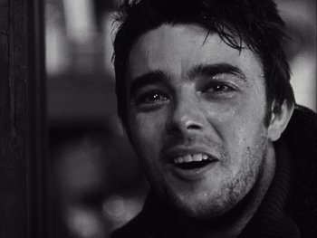 Movie still from “Le Beau Serge” (1958), directed by Claude Chabrol – Black and white photograph of a young man smiling for the camera; Close Up shot, Over the shoulder angle