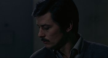 Movie still from “The Red Circle” (1970), directed by Jean-Pierre Melville – A person with a mustache; Close Up shot, Over the shoulder angle